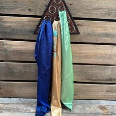 three different colored umbrellas hanging on a wooden wall