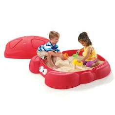 two children playing in a red sandbox