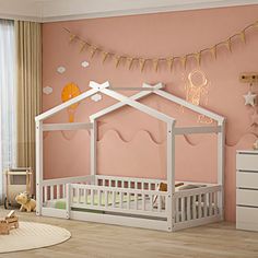 a child's bedroom with pink walls and white furniture, including a crib