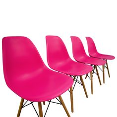 four pink chairs sitting next to each other on top of a white surface with wooden legs