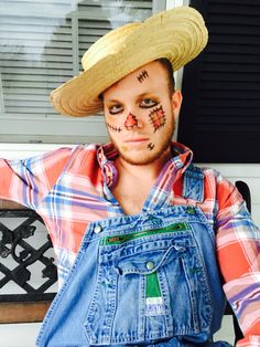 a man in overalls and a straw hat is sitting on a bench with his hands behind his head