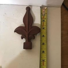 a measuring tape is next to a wall mounted fleur de lis