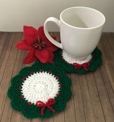 two crocheted coasters with poinsettia on them and a coffee cup