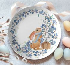 a plate with an image of a rabbit on it next to some eggs and flowers