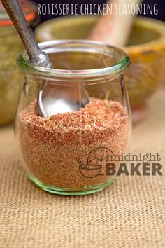 a glass jar filled with red sand next to some bananas and other fruit in the background