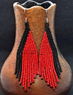 Add a touch of dramatic flair to your ensemble with these stunning red and black long fringe beaded earrings. These eye-catching earrings feature vibrant red and bold black beads meticulously handcrafted into an intricate fringe design. The sweeping strands of fringe dangle delicately, adding graceful movement and a sense of ethereal beauty to your look. Whether you're dressing up for a special occasion or adding a pop of color to your everyday style, these earrings will effortlessly elevate your outfit and make a bold statement. - 1 inch wide by 3.25 inches long -nickel free ear wires Be sure to check out my other handmade items here https://lesliesjewelryco.etsy.com Red Beaded Earrings With Tassels, Black Beaded Earrings With Tassels, Red Beaded Earrings With Tassels And Round Beads, Red Beaded Fringe Tassel Earrings With Round Beads, Traditional Black Jewelry With Beaded Fringe, Red Tassel Earrings With Fringe And Round Beads, Black Fringe Earrings With Round Beads, Red Long Drop Beaded Earrings, Red Fringe Earrings