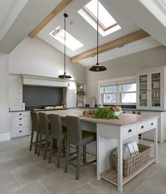 a large kitchen with an island in the middle and skylights on the ceiling above it