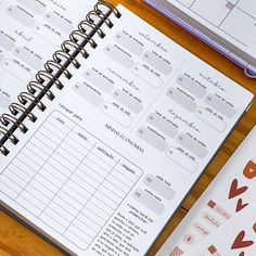 an open planner sitting on top of a wooden table