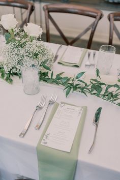 the table is set with flowers and silverware