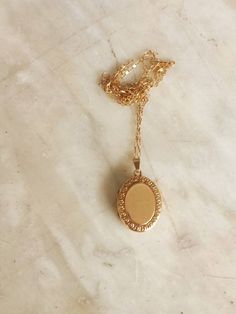 Early 20th century 9 ct gold oval  locket on a fine 9ct gold chain. The locket was made in the UK, probably around 1920, when the fashion changed from a preference for rose gold to yellow. It has a floral design framing the front; the back is plain. The locket is gold front and back; the frame and inside are of metal. The inside of the locket is intact, with room for a tiny photograph on  each side. The gold chain is a little later, probably c. 1930. Classic Gold Locket Necklace With Oval Pendant, Rose Gold Oval Locket Necklaces, Vintage Rose Gold Oval Locket Necklace, Dainty Gold Oval Pendant Locket Necklace, Dainty Gold Oval Locket Necklace, Vintage Gold Oval Link Locket Necklace, Victorian Gold Necklace With Oval Cabochon, Vintage Gold Locket Necklace With Oval Link, Victorian Gold Oval Cabochon Necklace