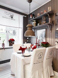 the dining room table is set with white linens and red bows on it's chairs