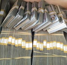 several stacks of money sitting on top of each other in front of a cell phone