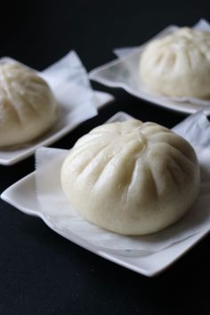 four small dumplings sitting on white plates