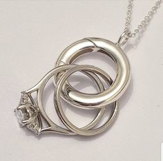 "Do you work in a job that you can't wear your rings?  Are you pregnant and can't currently put your rings on? Or do you simply want to wear a loved ones rigs around your neck? As a goldsmith the last thing I want to do with my engagement ring is leave it behind. So I have came up with this simplistic pendant that doubles as a ring keeper! You wouldn't know it's got a second purpose without really looking! Can be worn as a loop hanging on a chain or can be worn with your ring/s safely intertwine Ring Holder Pendant, Plain Ring, Diy Ring, Diy Xmas Gifts, Plain Rings, Loop Pendant, Diy Rings, Ring Holder, Ring Verlobung