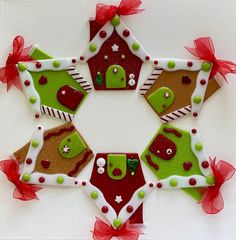 an ornament made to look like a gingerbread house with green and red decorations