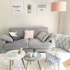 a living room with grey couches and white rugs on top of the floor