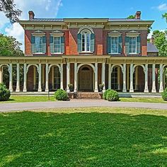 a large brick house with columns and arches