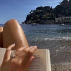 someone is reading a book on the beach