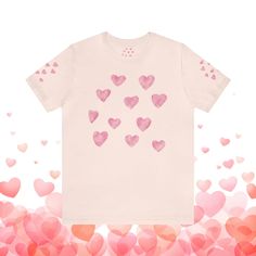 a white t - shirt with pink hearts on the front and back, against a background of red heart shapes