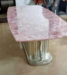 a pink marble dining table with silver pedestals