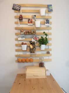 a wooden table topped with lots of pots and pans filled with food next to a wall mounted shelf