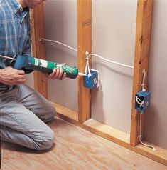 a man is working on an electrical outlet in the wall with a screwdriver