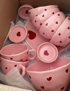 a box filled with lots of pink cups and saucers covered in red heart prints