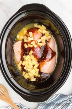 an image of food in the crock pot with meat and fruit on top, ready to be cooked