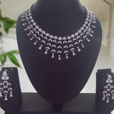 Indulge in the understated beauty of our 'Silver Lining' Western Necklace Set. The dazzling white stones lend a touch of brilliance, adding a hint of glamour to your look. Whether paired with casual attire or formal wear, this versatile set is sure to become a cherished addition to your jewelry collection, effortlessly enhancing your elegance. Our CZ Jewelry Sets are the most difficult ones to make. It takes over 80 hours of Design work to design each of these handcrafted Masterpieces. Handcraft White Glamorous Necklace With Diamond Accents, Glamorous White Necklace With Diamond Accents, White Cubic Zirconia Jewelry With Rhinestones, Diamond White Rhinestone Necklace, Dazzling Rhinestone Necklace With Diamond Accents, Glamorous White Necklace With Sparkling Stones, Dazzling Rhinestone Necklace With Sparkling Stones In Diamond White, Dazzling Diamond White Jewelry With Rhinestones, Dazzling Diamond White Sparkling Rhinestone Necklace