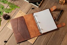 a brown and white binder sitting on top of a wooden floor next to a plant