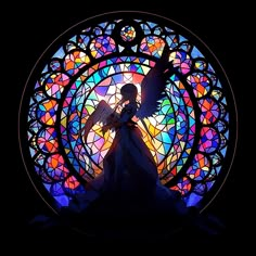 an angel standing in front of a stained glass window