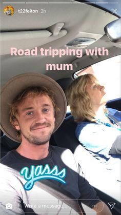 a man sitting in the back seat of a car next to a woman wearing a hat