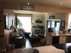 a living room filled with furniture next to a kitchen and dining room table in front of a doorway