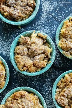 several small blue bowls filled with food on top of a table and covered in powdered sugar