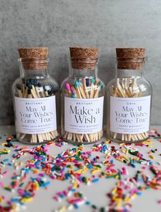 three bottles filled with matches sitting on top of a table covered in confetti