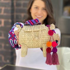 Elevate your fashion game with this playful and charming pig-shaped hand-woven raffia handbag from Oaxaca, Mexico. This bohemian straw bag with its unique design is perfect for anyone looking for a standout accessory. Complete with a hand-woven strap and a matching tassel, this bag captures the authentic craftsmanship and vibrant spirit of Mexican artistry. Whether you're in the market for fun handbags or simply adore bohemian straw bags, this piece is a delightful and expressive addition to your collection. Embrace the artistic tradition of hand-woven straw while showcasing your free-spirited style with this boho-chic raffia handbag.Pompons may vary but will match the color of the strap . Dimensions:Length: 12-11 inches.Height: 9-7 inches.Strap: 34-36 inches length. 17 inches drop approx. Pig Handbags, Handcrafted Boots, Painted Hats, Free Spirit Style, Cashmere Shawl, Woven Raffia, Shoulder Backpack, Straw Bags, Aqua Turquoise