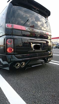 the rear end of a black van parked in a parking lot