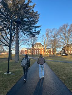 two people walking down a path in the park