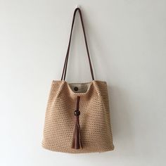 IN STOCK FAST SHIPPING FROM LOS ANGELES This stylish and functional Elena Handbags Handmade Retro Woven Shoulder Bag is crafted from high quality cotton and features a handmade detail, a decorative tassle, an inner lining and pocket, and a magnetic button closure. Its unique retro design ensures you will stand out from Beige Crochet Bag With Tassels For Travel, Beige Hobo Bag With Tassels For Daily Use, Brown Rectangular Cotton Hobo Bag, Rectangular Brown Cotton Hobo Bag, Brown Bohemian Cotton Shoulder Bag, Casual Brown Crochet Bag With Tassels, Handmade Brown Canvas Bag Casual Style, Cotton Shoulder Bag With Leather Handles For Beach, Everyday Straw Shoulder Bag With Tassels