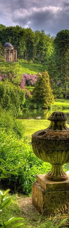 a large stone fountain sitting in the middle of a lush green park