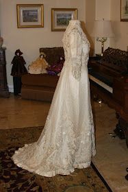 a wedding dress on display in front of a piano