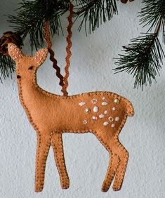 a felt deer ornament hanging from a christmas tree