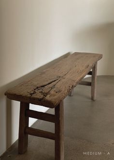 a wooden bench sitting in the middle of a room next to a wall and floor