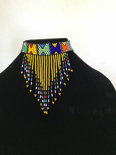 100 % Handmade with fine beads. One size fits most, Beaded Zulu tassel necklace that can also be worn as a head band. The band is multicolored and the tassel has a solid color with a finish of different colors. We have five solid colors for the tassel, Red, Orange, Blue, white and yellow. Made in South Africa, Durban. Adjustable Tassel Jewelry For Festivals, Traditional Beaded Fringe Necklace, Traditional Multicolor Beaded Fringe Necklaces, Traditional Multicolor Beaded Necklaces With Fringe, Traditional Multicolor Beaded Necklace With Fringe, Traditional Multicolor Jewelry With Beaded Fringe, Traditional Adjustable Beaded Fringe Necklaces, Traditional Adjustable Beaded Fringe Necklace, Traditional Colorful Bead Choker