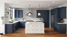 a large kitchen with blue cabinets and white counter tops is pictured in this image, it appears to be empty