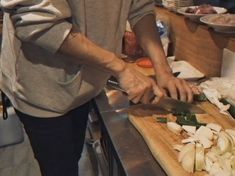 a person chopping onions on a cutting board with a knife in the middle of it