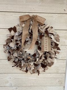 a wreath that has been made out of old newspaper strips and burlap ribbon