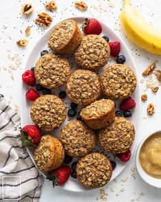 muffins on a plate with berries and walnuts next to a bowl of oatmeal