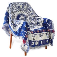 a blue and white table cloth with zodiac signs on it sitting on a wooden chair