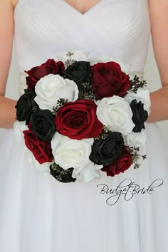 a woman in a white dress holding a red and black bridal bouquet with roses